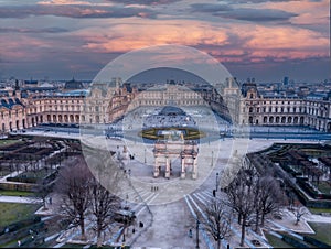 Aerial view of Louvre museum in Paris, France with glass pyramide and dramatic sky