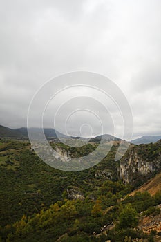 Aerial view of low clouds, mountains, sea and colorful sky at sunset. Above the clouds at dusk. Amazing landscape with cloudy sky