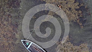 Aerial view of low tide seascape. Blue boat in low water ocean rounded of rocks and moss. Drone point of view of irish