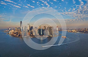 Aerial view of lower Manhattan financial district with modern architecture office buildings shot from helicopter at golden hour