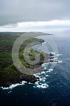 Aerial view of a lush green and blue landscape featuring a vast expanse of ocean and lush green land