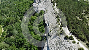 Aerial view of lush green farm field at spring sunny day with rocky cliffs in the distance. beauty of rural areas and