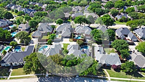 Aerial view lush greenery suburban residential neighborhood subdivision, row of upscale two-story houses with swimming