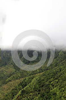 An aerial view of the lush and verdant mountainsides and valleys with two waterfalls in Waimea Canyon State Park