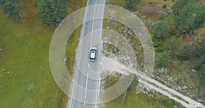 Aerial view of a luxury car driving on country road