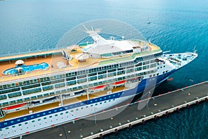 Aerial view of a luxury cruise ship or linear with a swimming pool on the roof moored in marina.