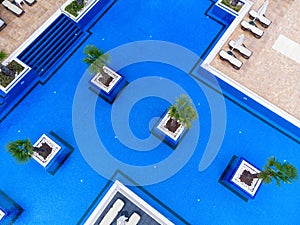 Aerial view of luxury outdoor swimming pool and deck-chairs