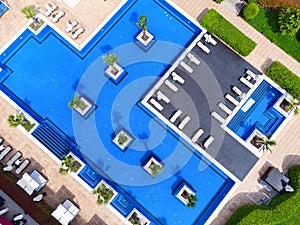 Aerial view of luxury outdoor swimming pool and deck-chairs