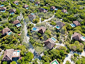 Aerial view of luxury villa with swimming pool in tropical forest.