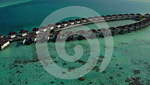 Aerial view of luxury villas over water on blue lagoon