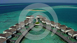 Aerial view of luxury villas over water on blue lagoon