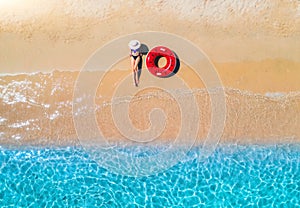 Aerial view of a lying woman in hat with red swim ring