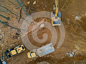 Aerial view machinery and heavy-duty equipments at large construction site of excavator, bulldozer, dump truck, digger
