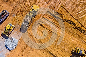 Aerial view machinery and heavy-duty equipments at large construction site of excavator, bulldozer, dump truck, digger