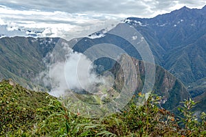 Aerial view of Machu Picchu Inca citadel in the clouds, located on a mountain ridge above the Sacred Valley