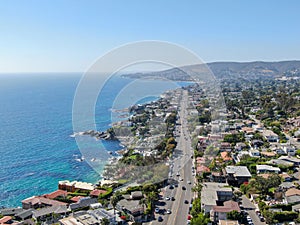 Aerial view of main road crossing Laguna Beach coastline town with houses on the hills, Califronia