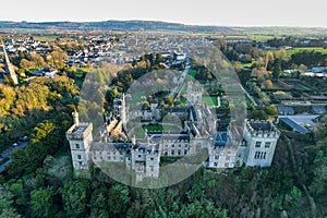 Aerial view of majestic Lismore Castle in County Waterford, Ireland, bathed in the golden glow of the setting sun