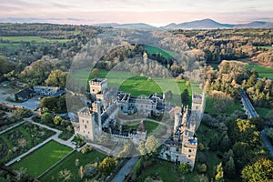 Aerial view of majestic Lismore Castle in County Waterford, Ireland, bathed in the golden glow of the setting sun