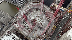Aerial View Of Major Construction Site With Multiple Red Cranes and Steel Framework Along Riverbank photo