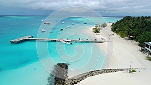 Aerial view of Maldives tropical beach with pier and speed boats in ocean. Summer and travel vacation concept.