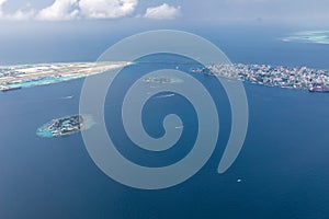 Aerial view of Male capital Maldives islands, blue sea ocean lagoon, islands and resorts with speedboats passing by