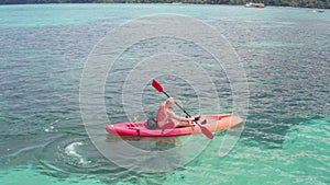 Aerial view of man kayaking in crystal clear sea water near Koh Kra island in Thailand