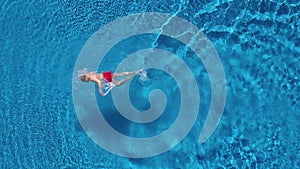 Aerial view of man in red shorts swims in the pool