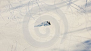 Aerial view a man riding a bicycle on snowy lake