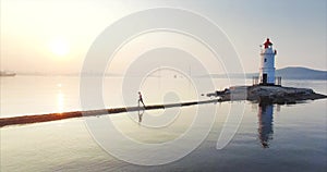 Aerial view of man running fast along the spit at sunrise. Vladivostok, Russia