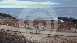 Aerial view of man and woman runnning along the nature reserve at sunrise. Healthy active lifestyle