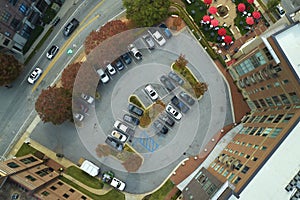 Aerial view of many colorful cars parked on parking lot on apartment building backyard. Place for vehicles in front of