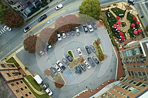 Aerial view of many colorful cars parked on parking lot on apartment building backyard. Place for vehicles in front of