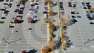 Aerial view of many colorful cars parked on parking lot with lines and markings for parking places and directions. Place