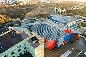 Aerial view of many photo voltaic solar panels mounted of industrial building roof