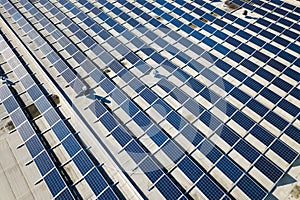 Aerial view of many photo voltaic solar panels mounted of industrial building roof