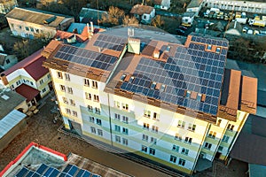 Aerial view of many photo voltaic solar panels mounted of industrial building roof