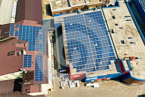 Aerial view of many photo voltaic solar panels mounted of industrial building roof