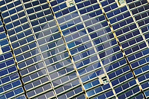 Aerial view of many photo voltaic solar panels mounted of industrial building roof