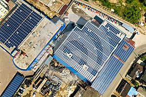 Aerial view of many photo voltaic solar panels mounted of industrial building roof