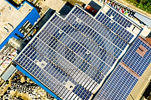 Aerial view of many photo voltaic solar panels mounted of industrial building roof