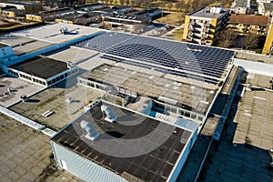 Aerial view of many photo voltaic solar panels mounted of industrial building roof