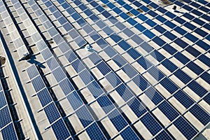 Aerial view of many photo voltaic solar panels mounted of industrial building roof