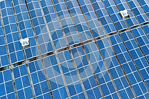 Aerial view of many photo voltaic solar panels mounted of industrial building roof