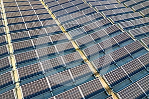 Aerial view of many photo voltaic solar panels mounted of industrial building roof