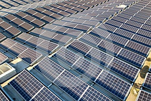 Aerial view of many photo voltaic solar panels mounted of industrial building roof