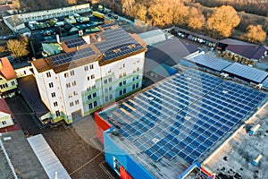 Aerial view of many photo voltaic solar panels mounted of industrial building roof