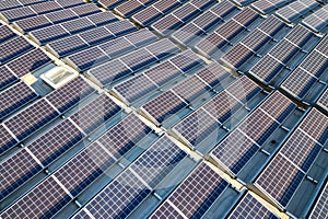 Aerial view of many photo voltaic solar panels mounted of industrial building roof