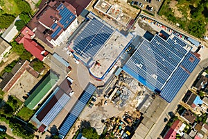 Aerial view of many photo voltaic solar panels mounted of industrial building roof