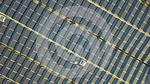 Aerial view of many photo voltaic solar panels mounted of industrial building roof.