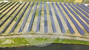 Aerial view of many photo voltaic solar panels mounted of industrial building roof.